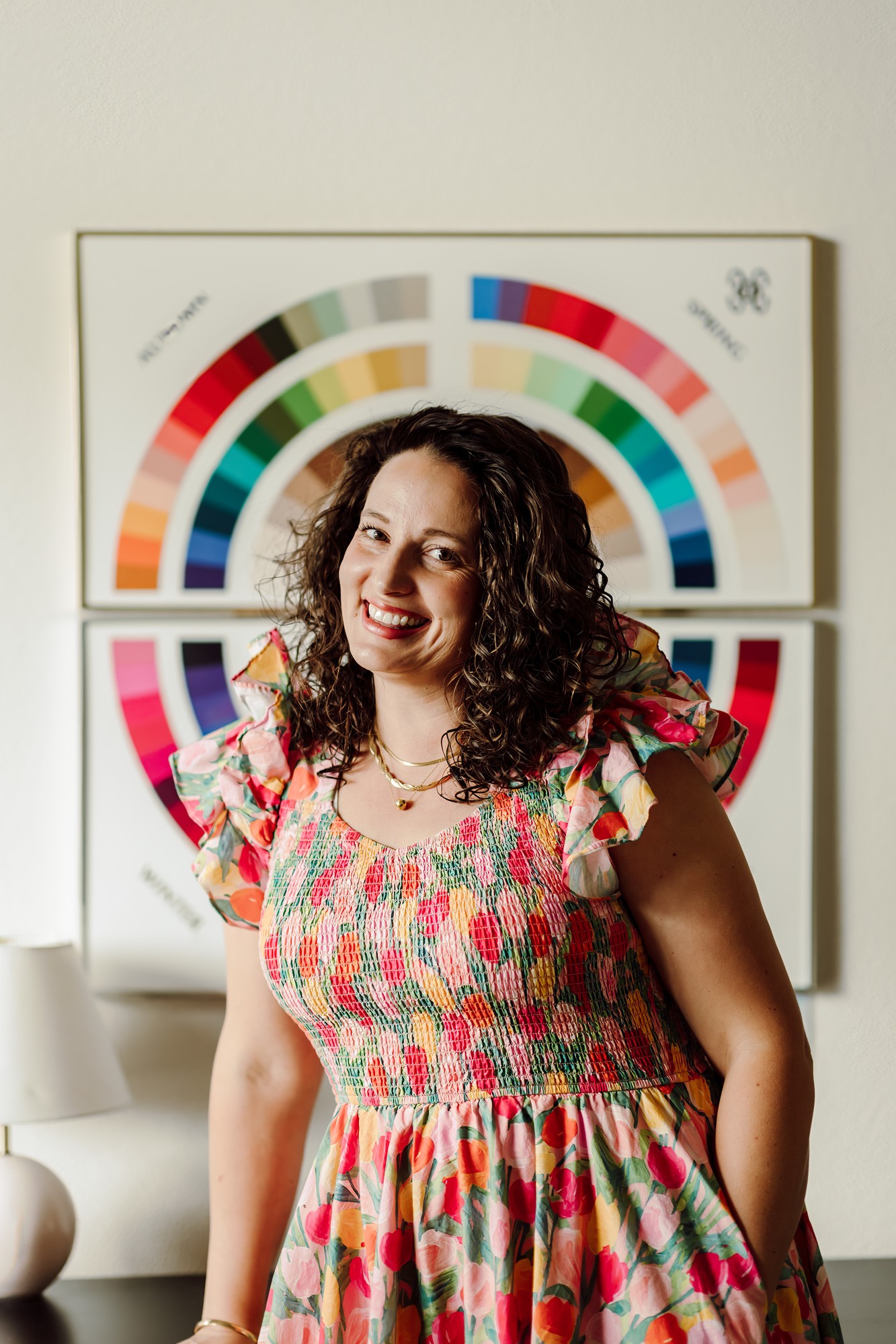 Business owner smiling in front of framed color-wheel wall art